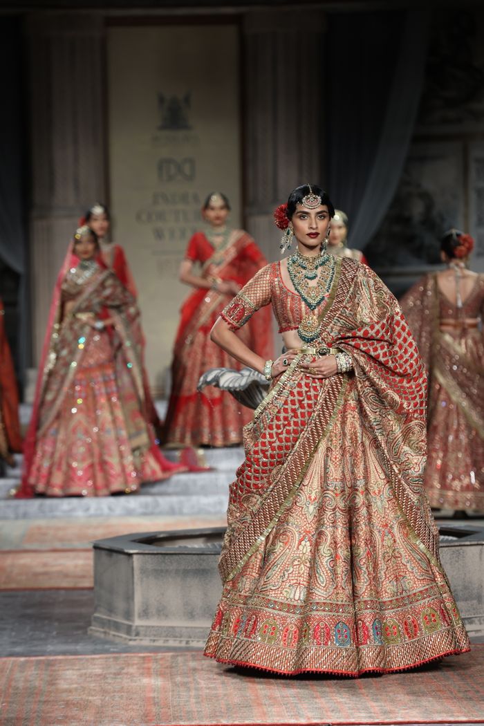 Experience the elegance of traditional Indian fashion with vibrant saris on the runway in New Delhi.
